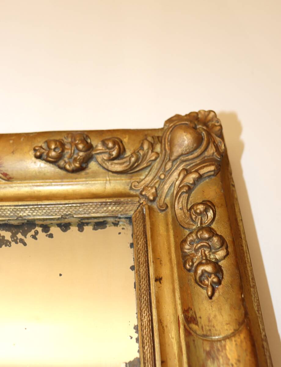 Rectangular mirror in gilded wood with relief decoration of flowers.
