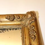 Rectangular mirror in gilded wood with relief decoration of flowers.