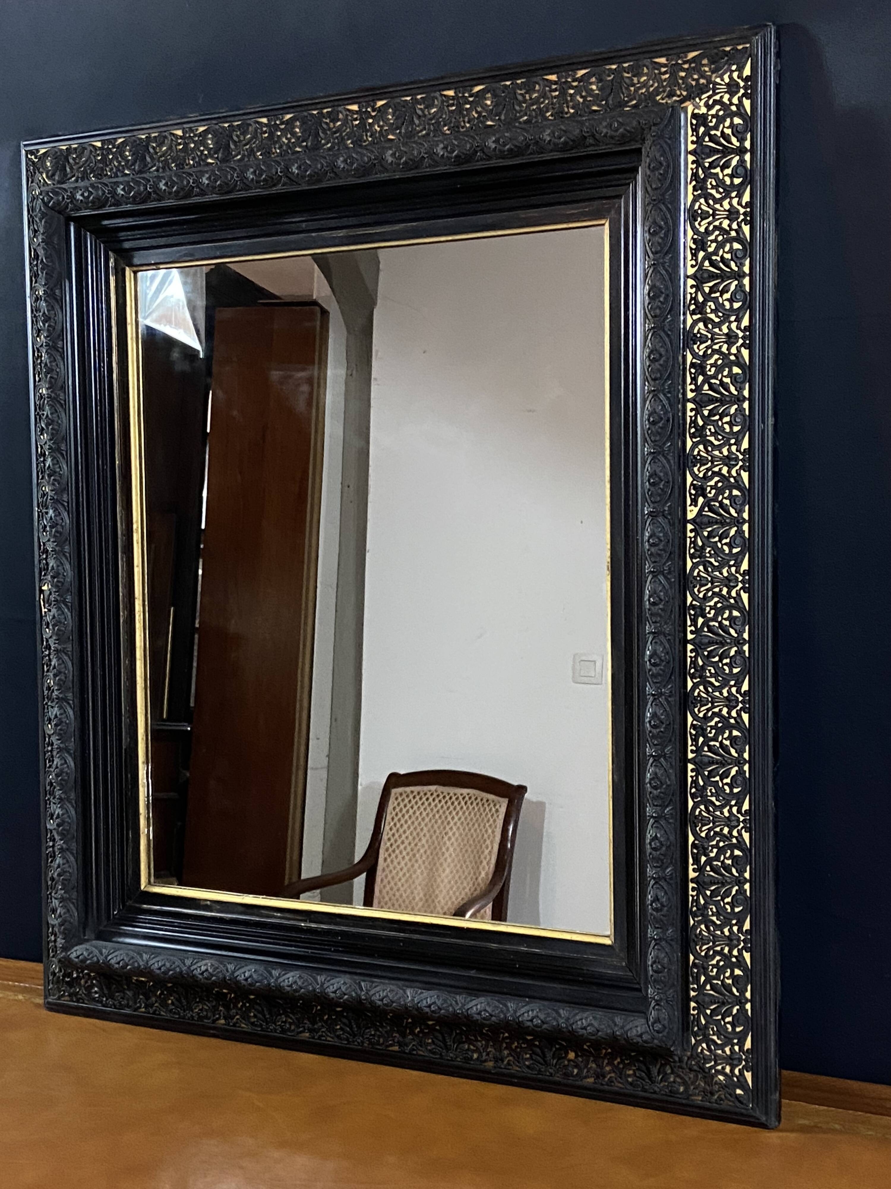 19th-century mirror Napoleon III in blackened wood on a gold background.