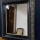 19th-century mirror Napoleon III in blackened wood on a gold background.