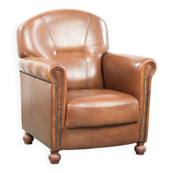 Fauteuil en cuir de peau de mouton avec finition décorative en clous raffinés.