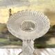 Tall molded glass candle holder with ram heads