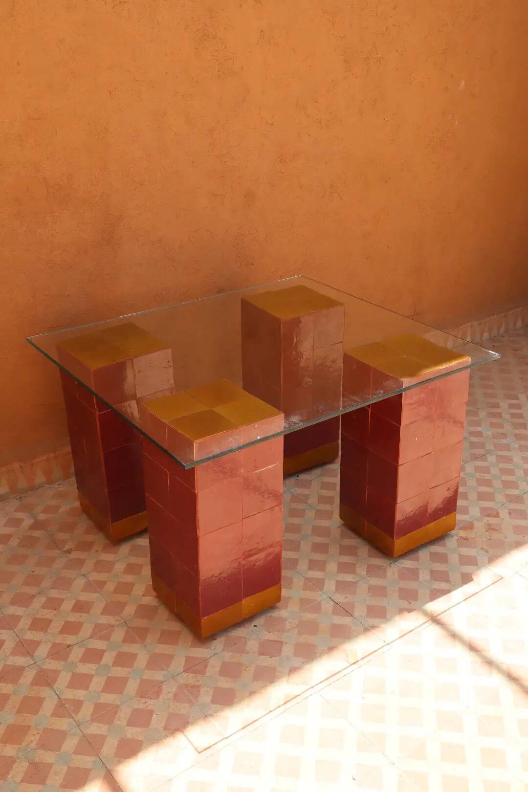 Modern coffee table in burgundy zellige with a tempered glass top.