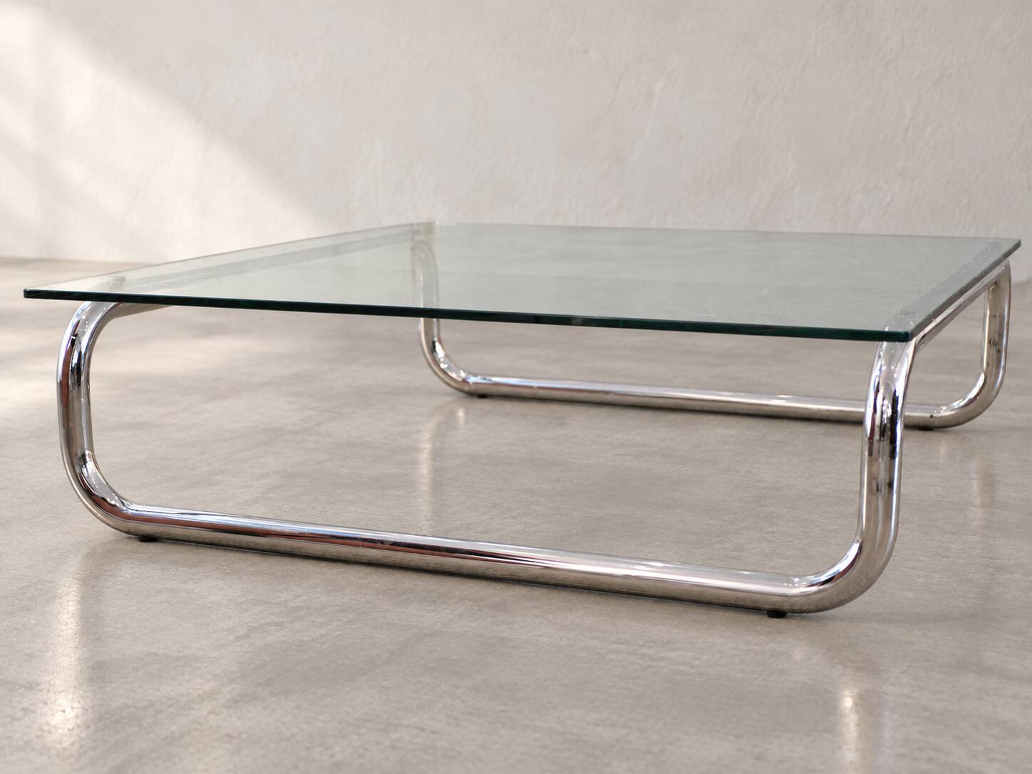 Coffee table in chrome with a glass top.