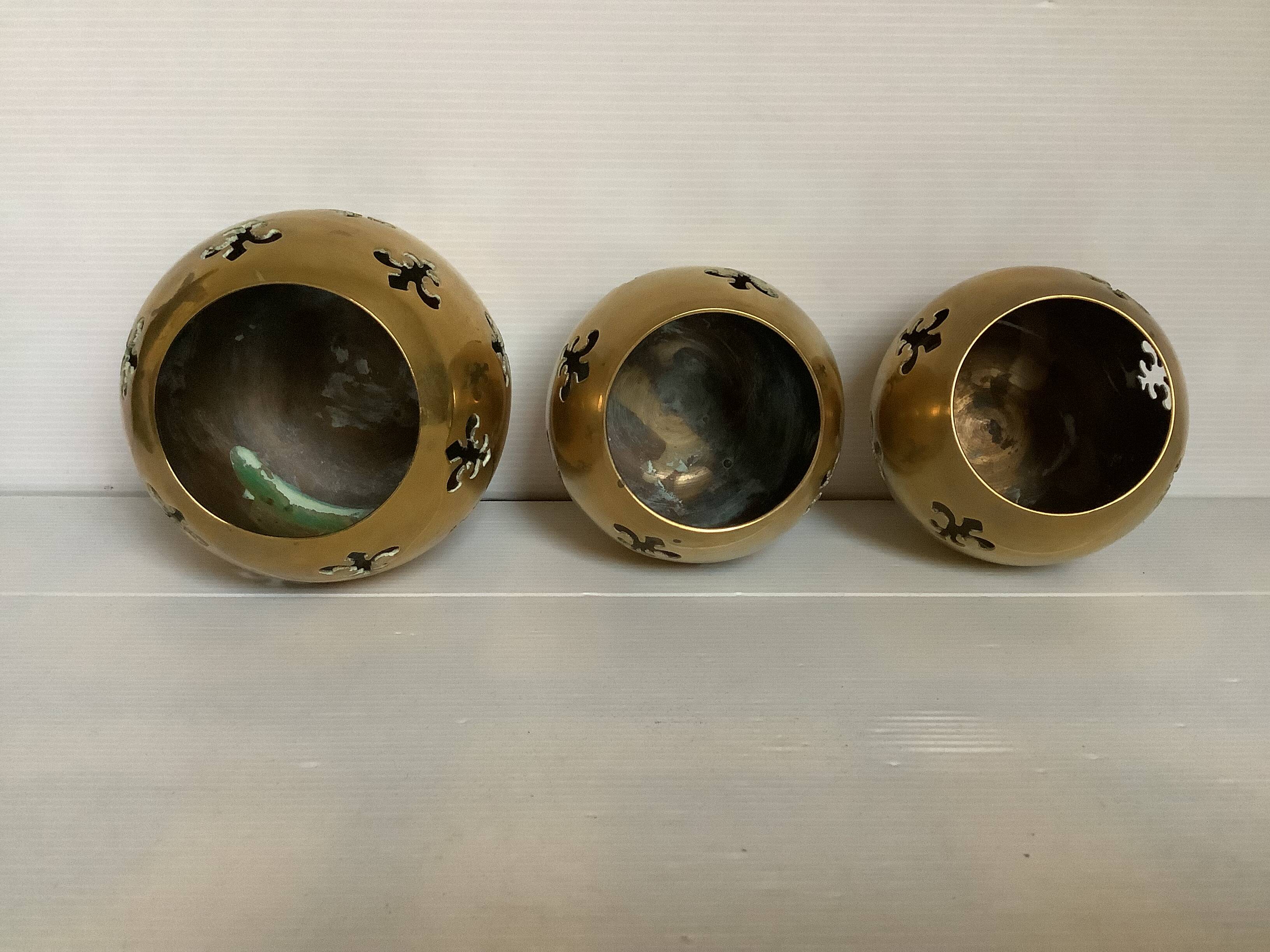 Trio of brass fleur-de-lis candle holders