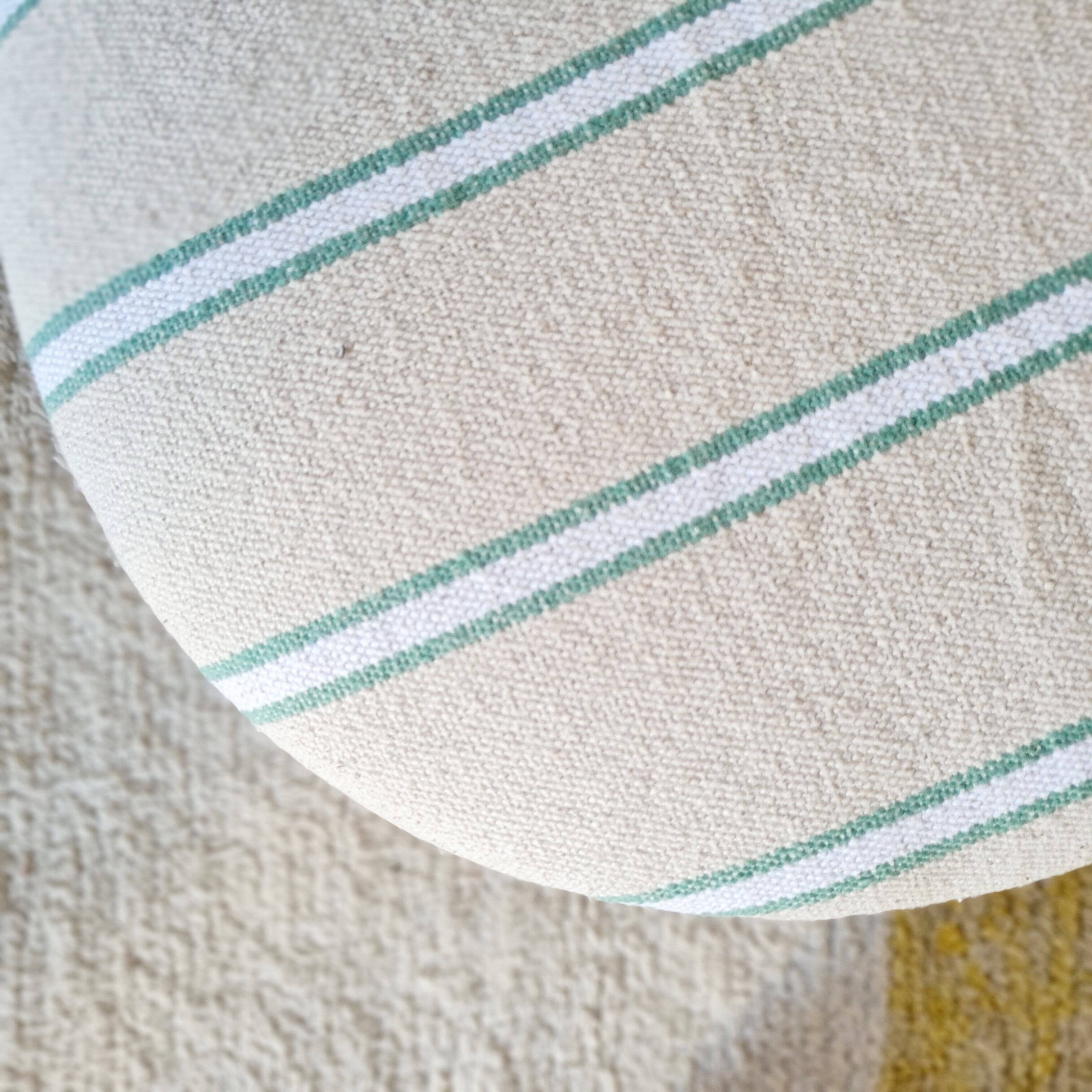 Antique stool with a wooden frame and a cream and green striped fabric seat.
