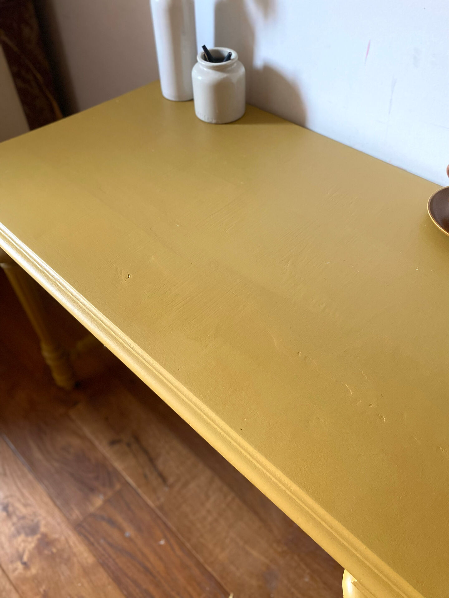 Desk table from the late 19th century, painted mustard, with turned stretcher.