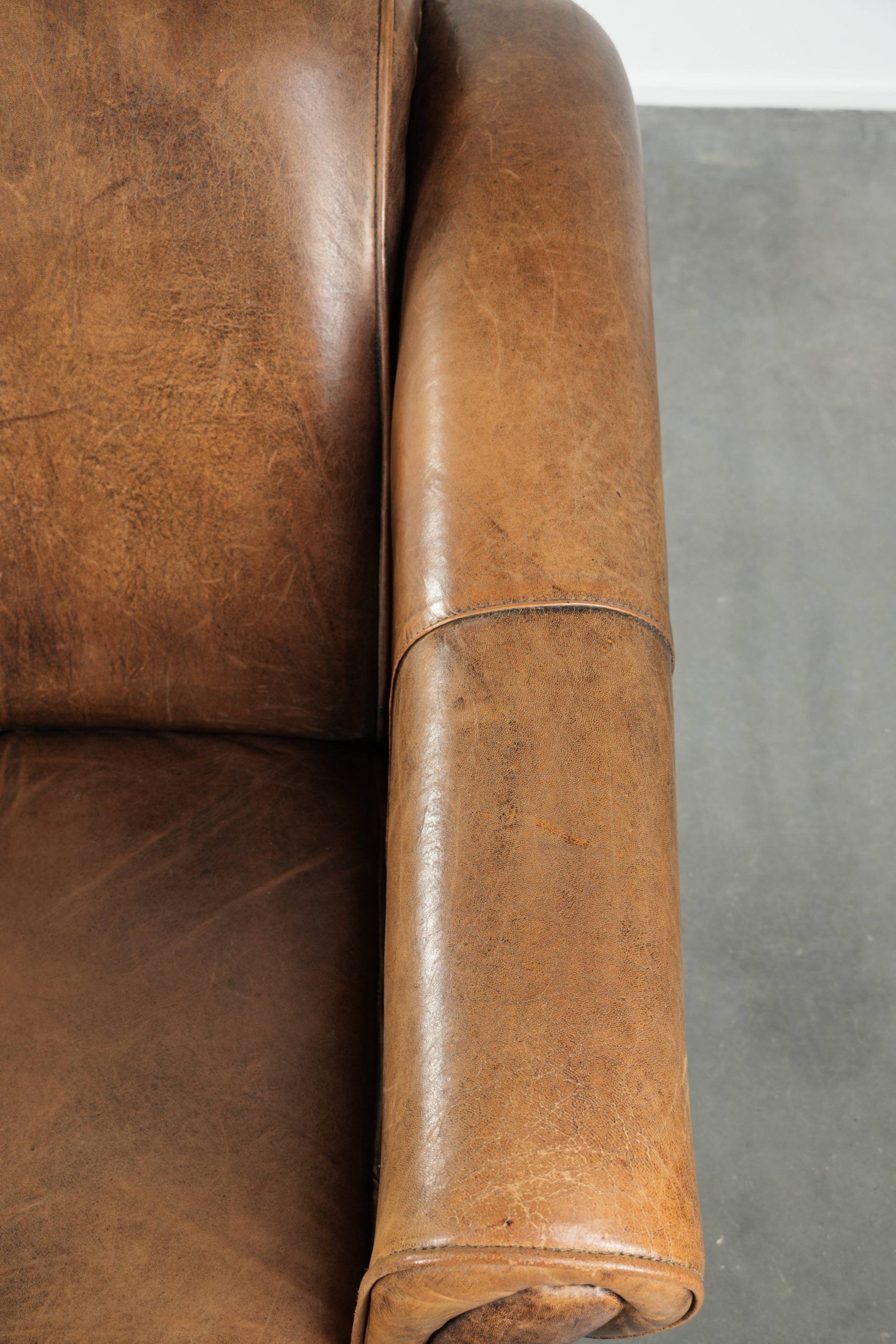 Fauteuil en peau de mouton magnifiquement conçu et confortable, avec un look intemporel et une finition de passepoil assortie.