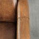 Fauteuil en peau de mouton magnifiquement conçu et confortable, avec un look intemporel et une finition de passepoil assortie.