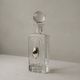 Vintage glass decanter from the 1980s, transparent glass with a silver plate and spherical stopper.