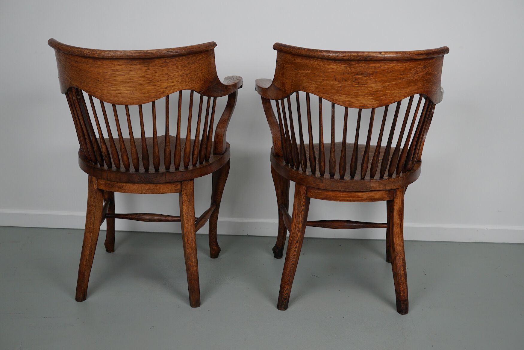 Pair of English Edwardian Oak Spindle Back Captains Office Desk Chairs