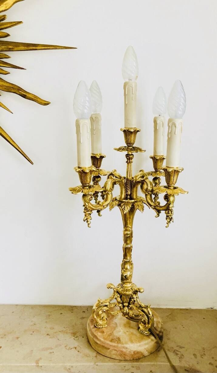 Massive gilded bronze chandeliers from the mid-20th century with marble bases.