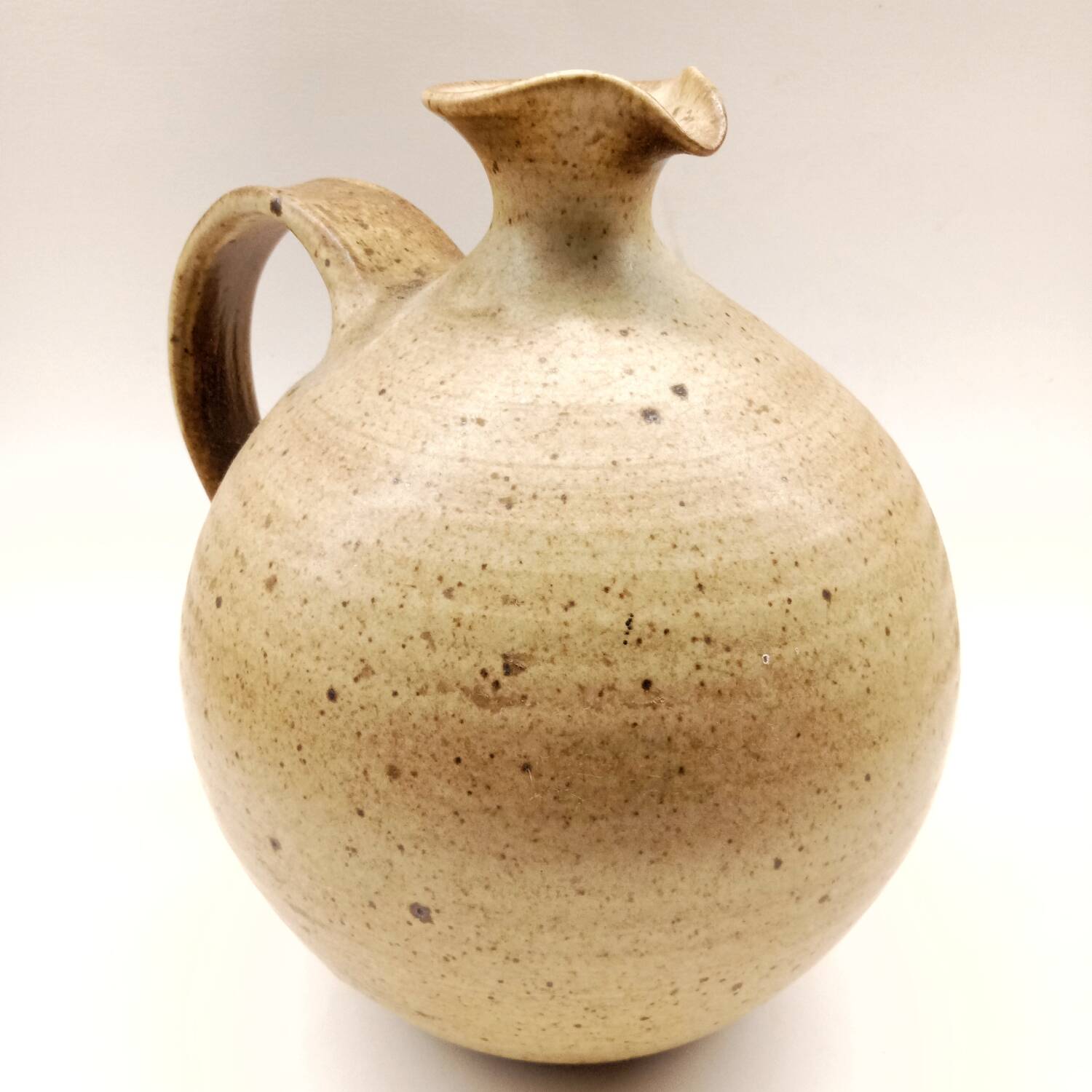 Vintage speckled brown stoneware jug in a round shape.