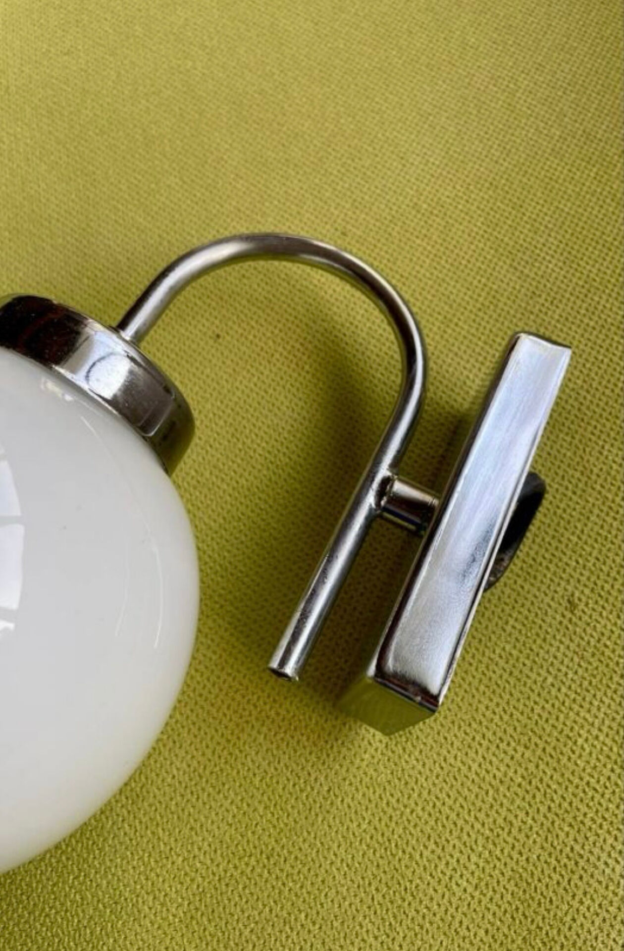 Pair of chrome metal wall lights with white glass globe.