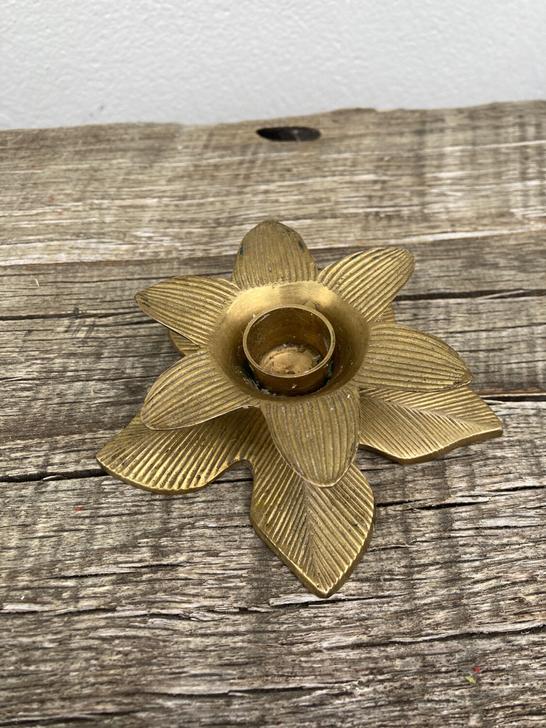 Old golden brass candle holder in the shape of a leaf or flower