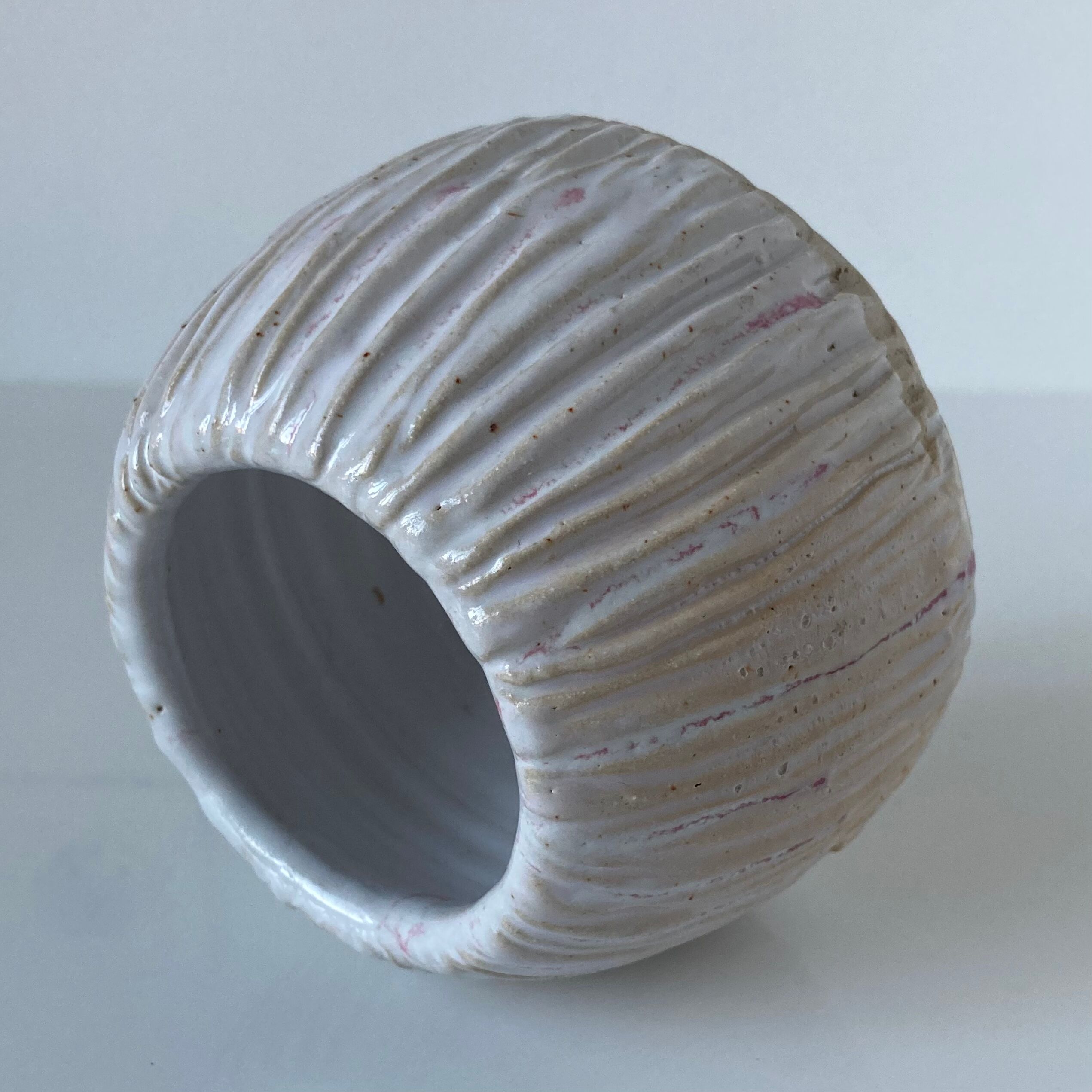 Meeting of three artist's ceramic objects including two pots and a cream covered bowl