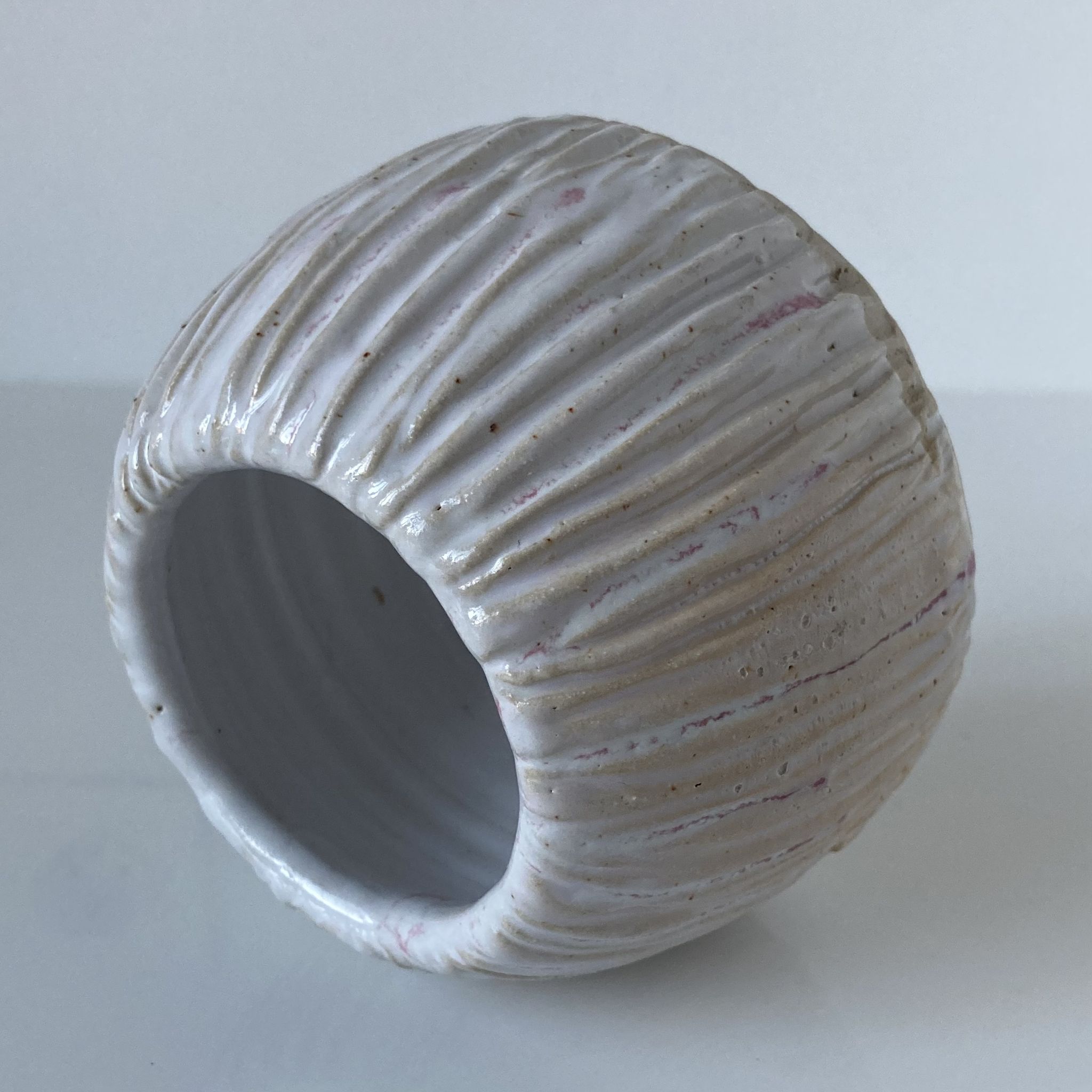 Meeting of three artist's ceramic objects including two pots and a cream covered bowl