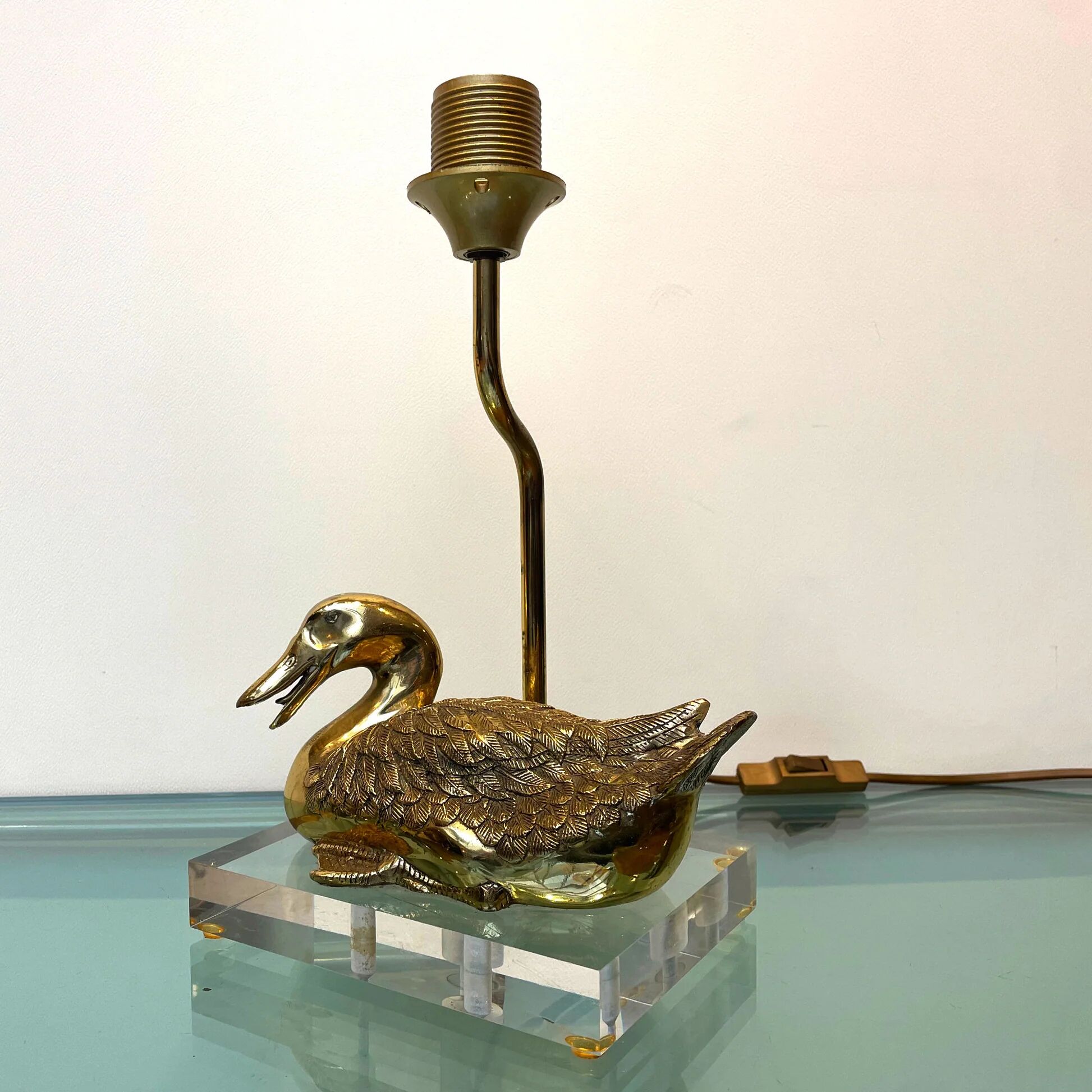Vintage brass table lamp in the shape of a duck from the 1970s on an acrylic base.