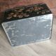 Old black metal box and flowers at the beginning of the century