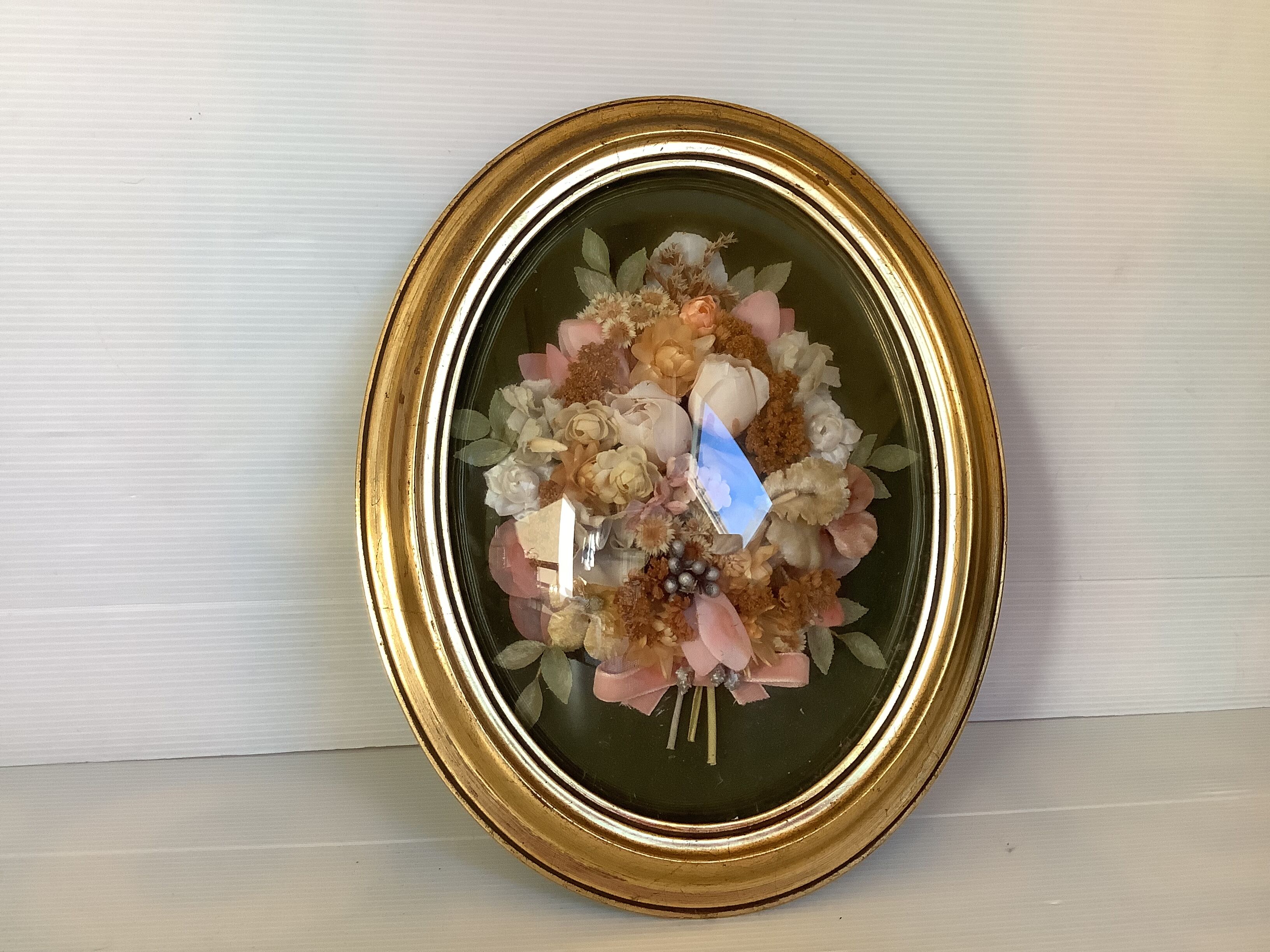 Golden oval frame dried flowers