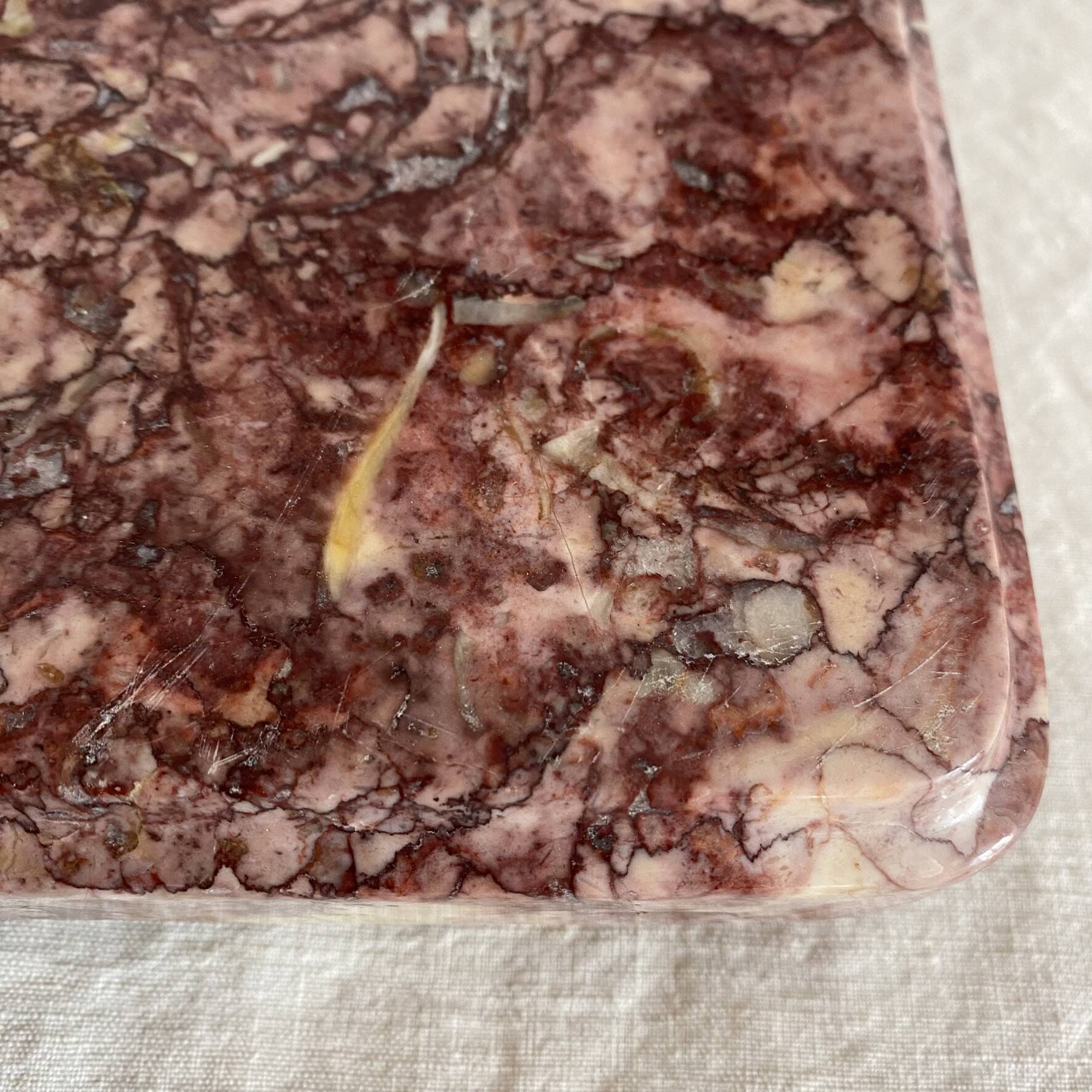 Pink marble trivet with brass ball feet.