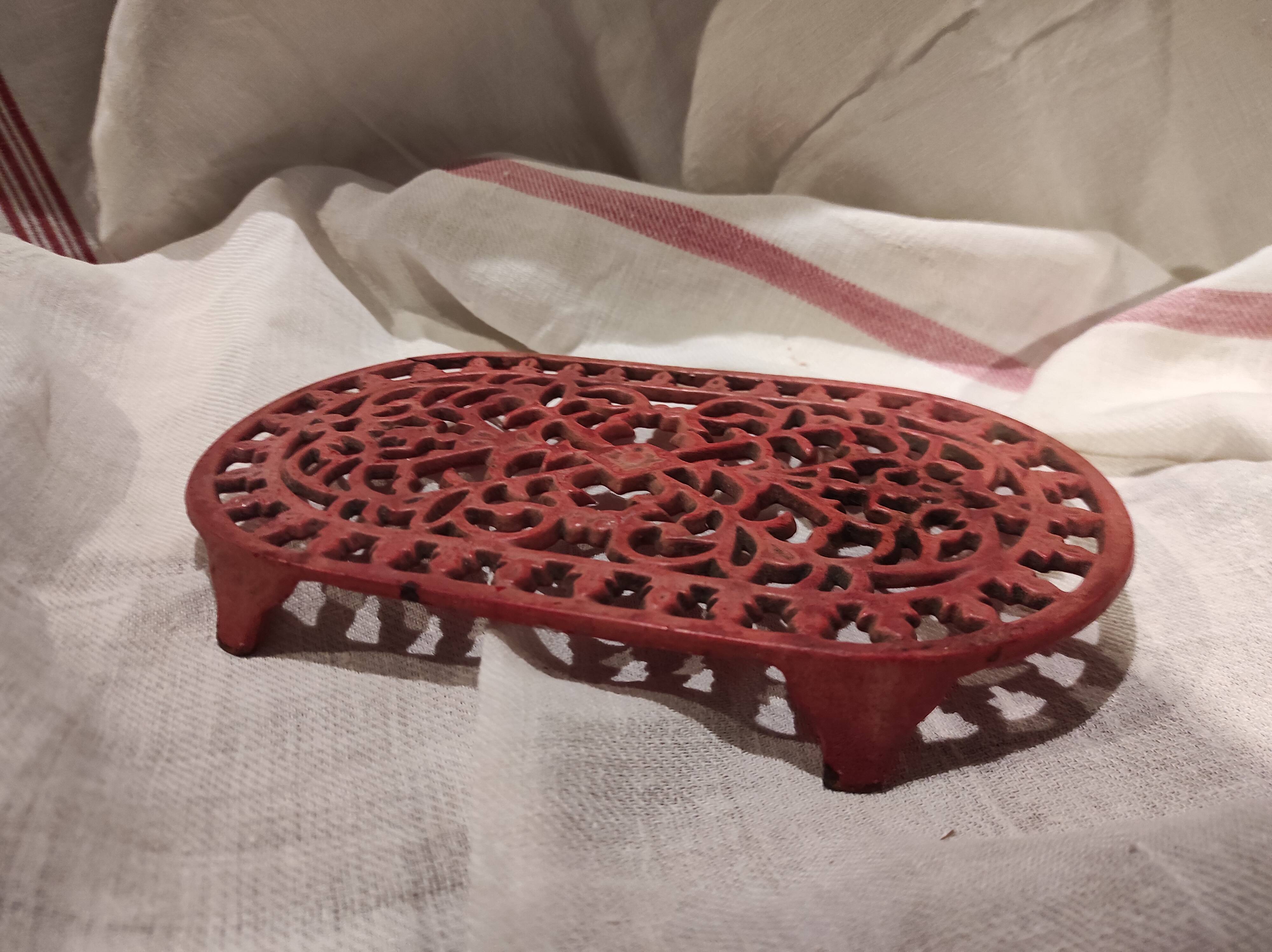 Vintage oval dark coral pink cast iron trivet
