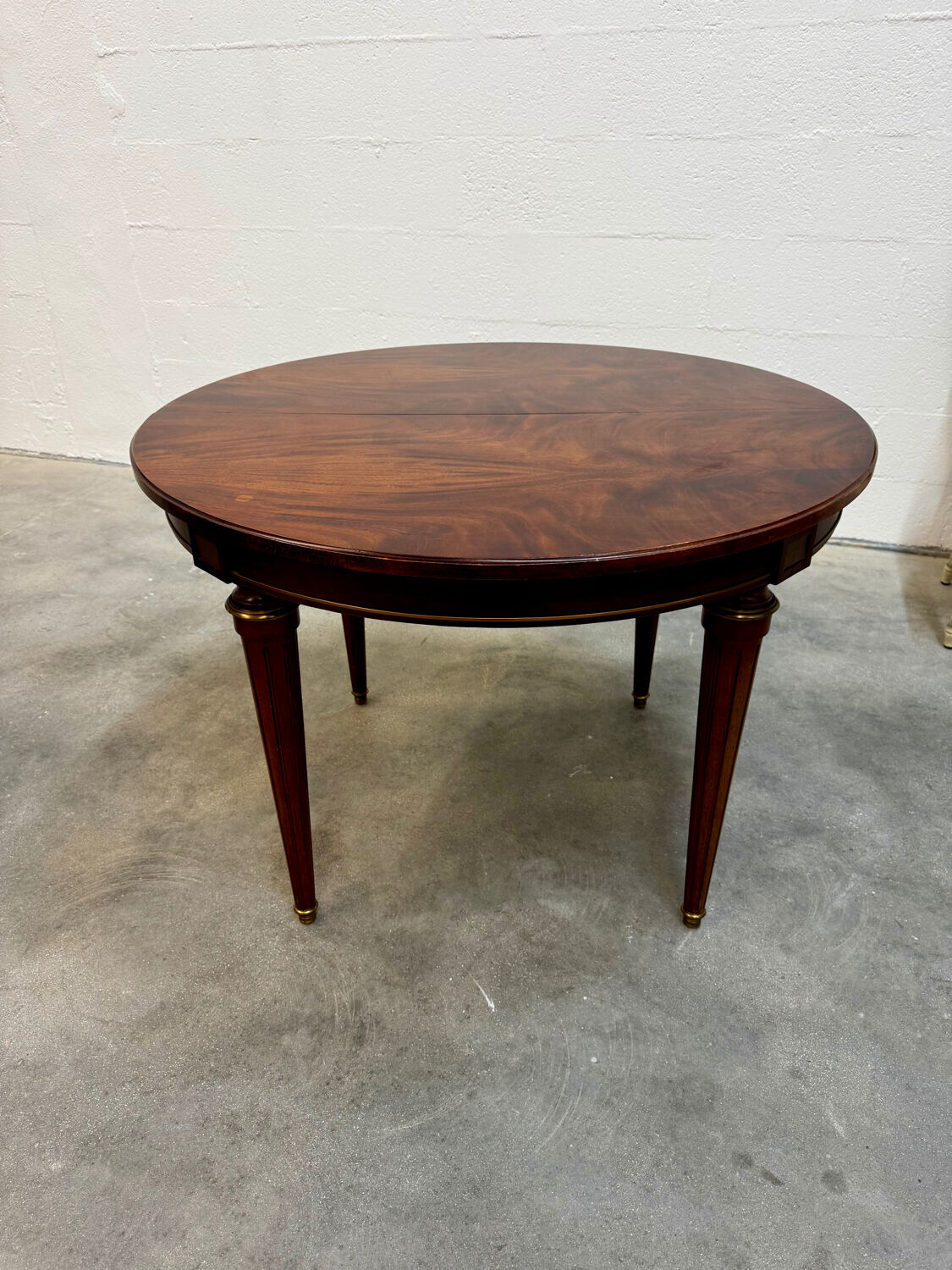 Extendable mahogany round table in Louis XVI style