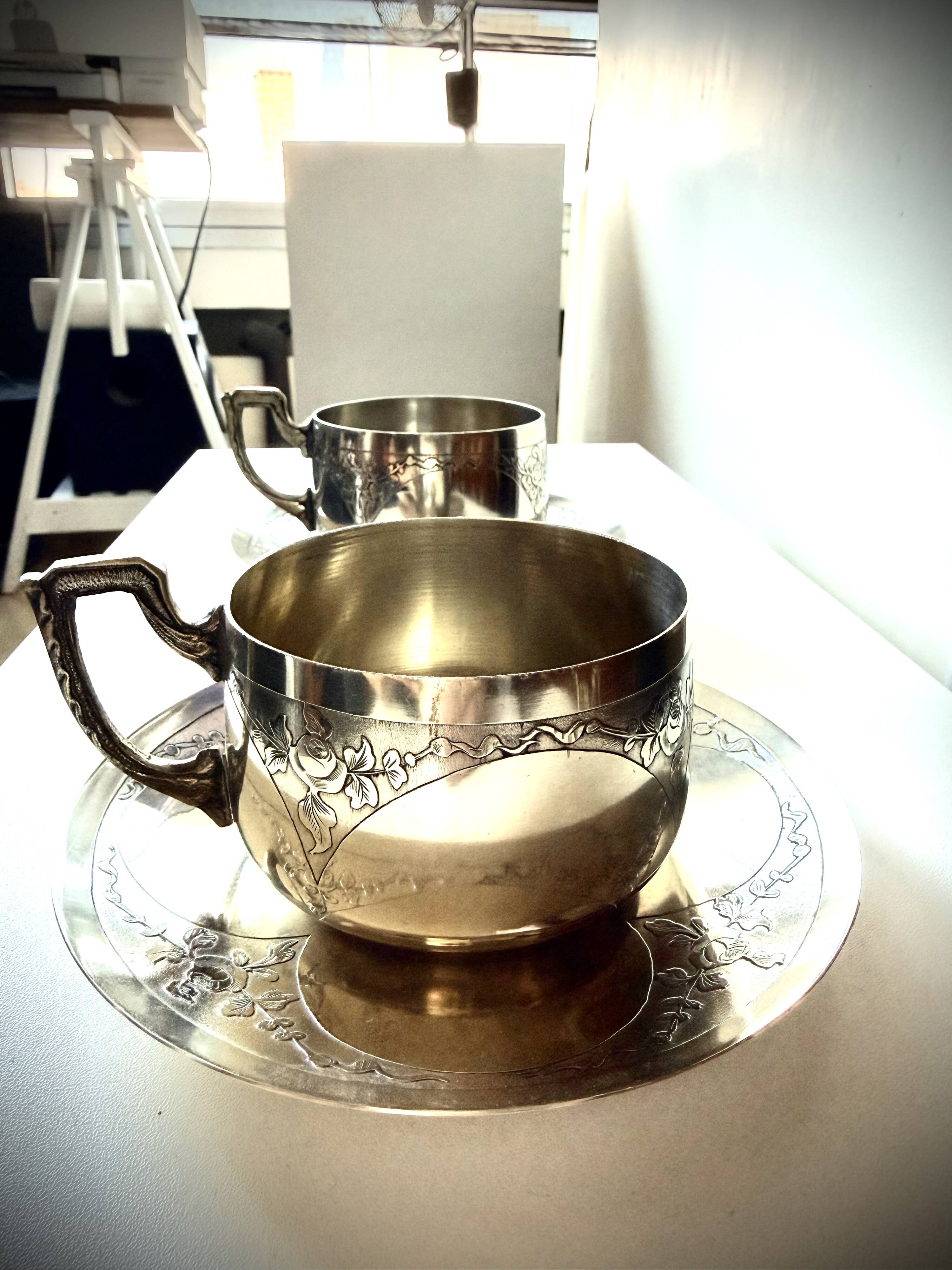 Set of 2 cups with silver-plated saucers, 19th century.