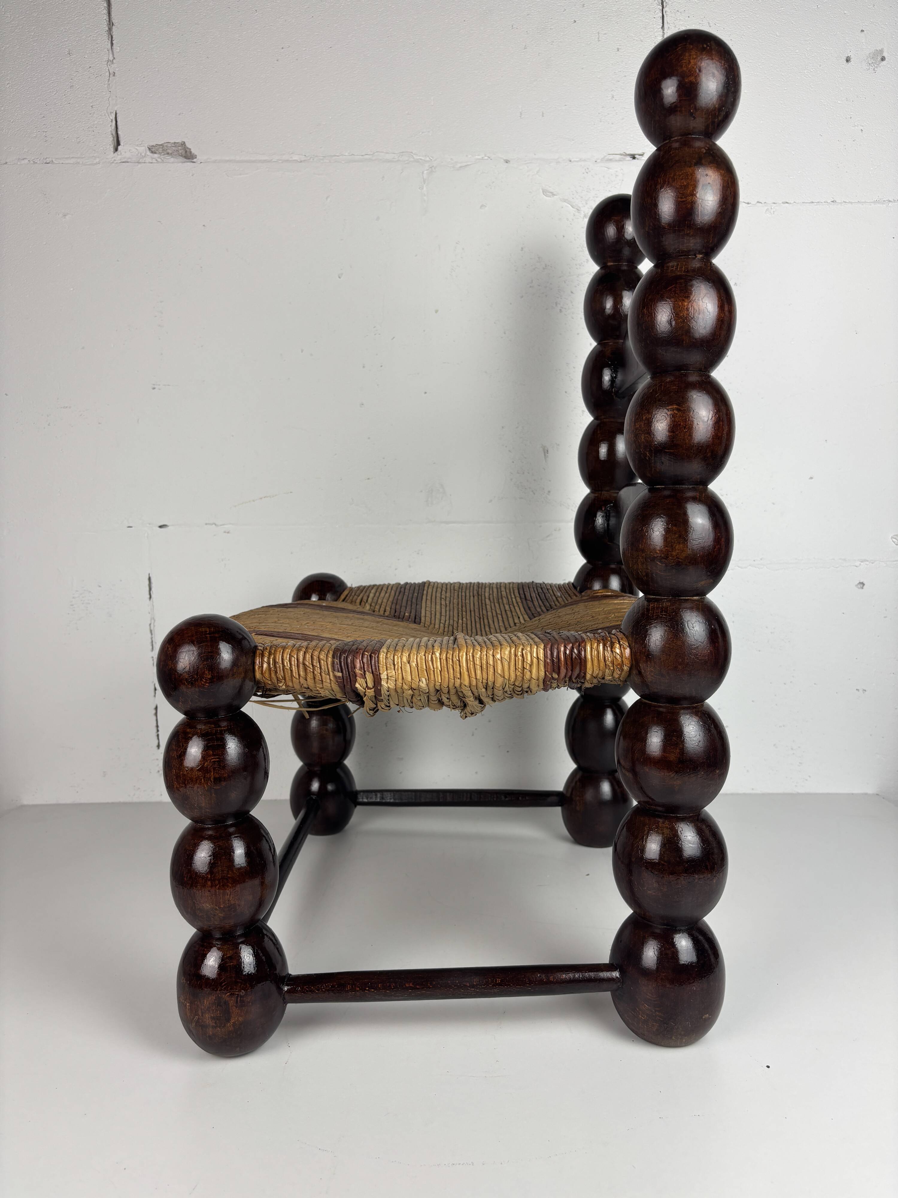 Brutalist wood turned bobbin low rush chair n the style of Charles Dudouyt