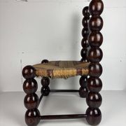 Brutalist wood turned bobbin low rush chair n the style of Charles Dudouyt