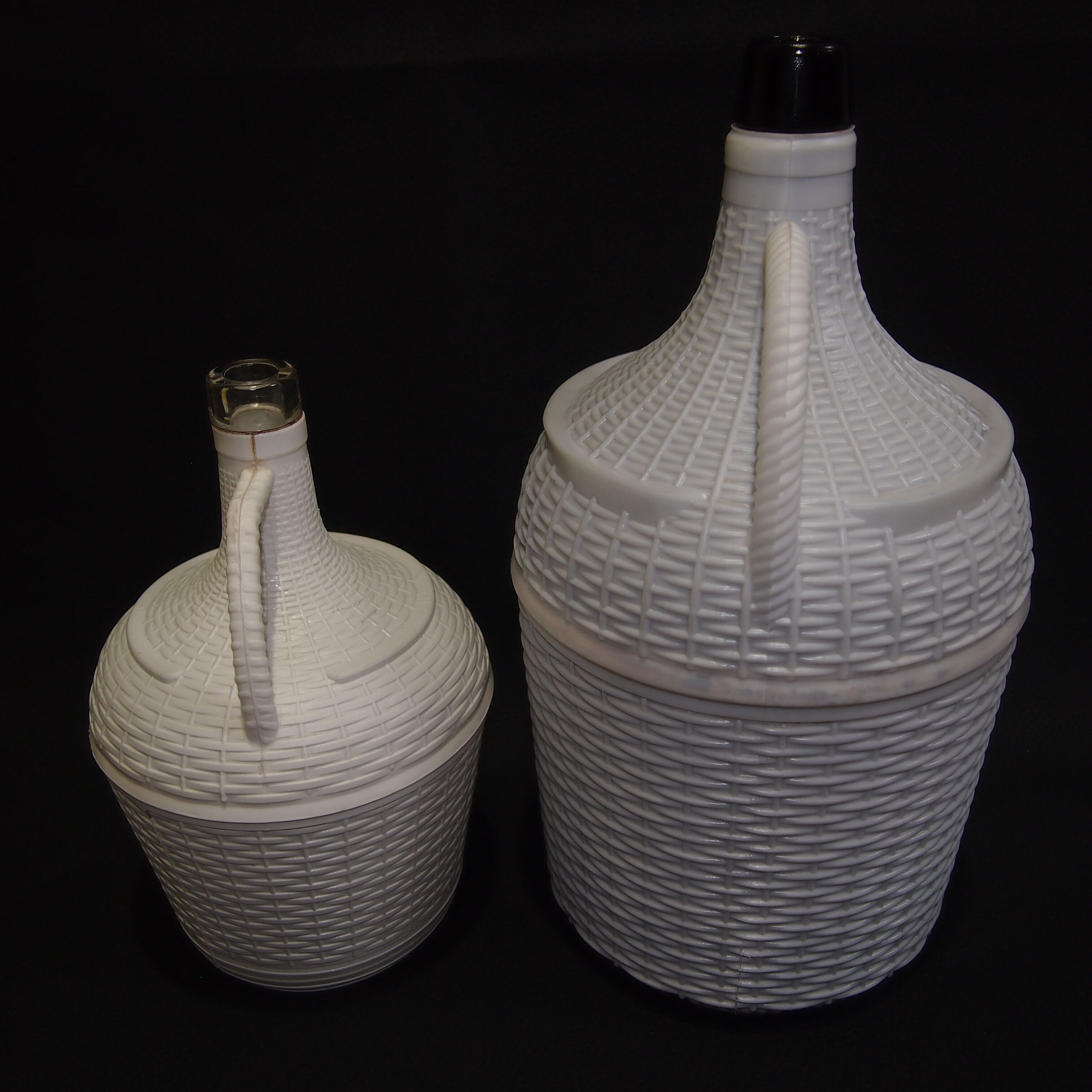 Pair of white covered demijohns