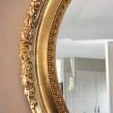 Beveled oval mirror with carved gilded wood frame