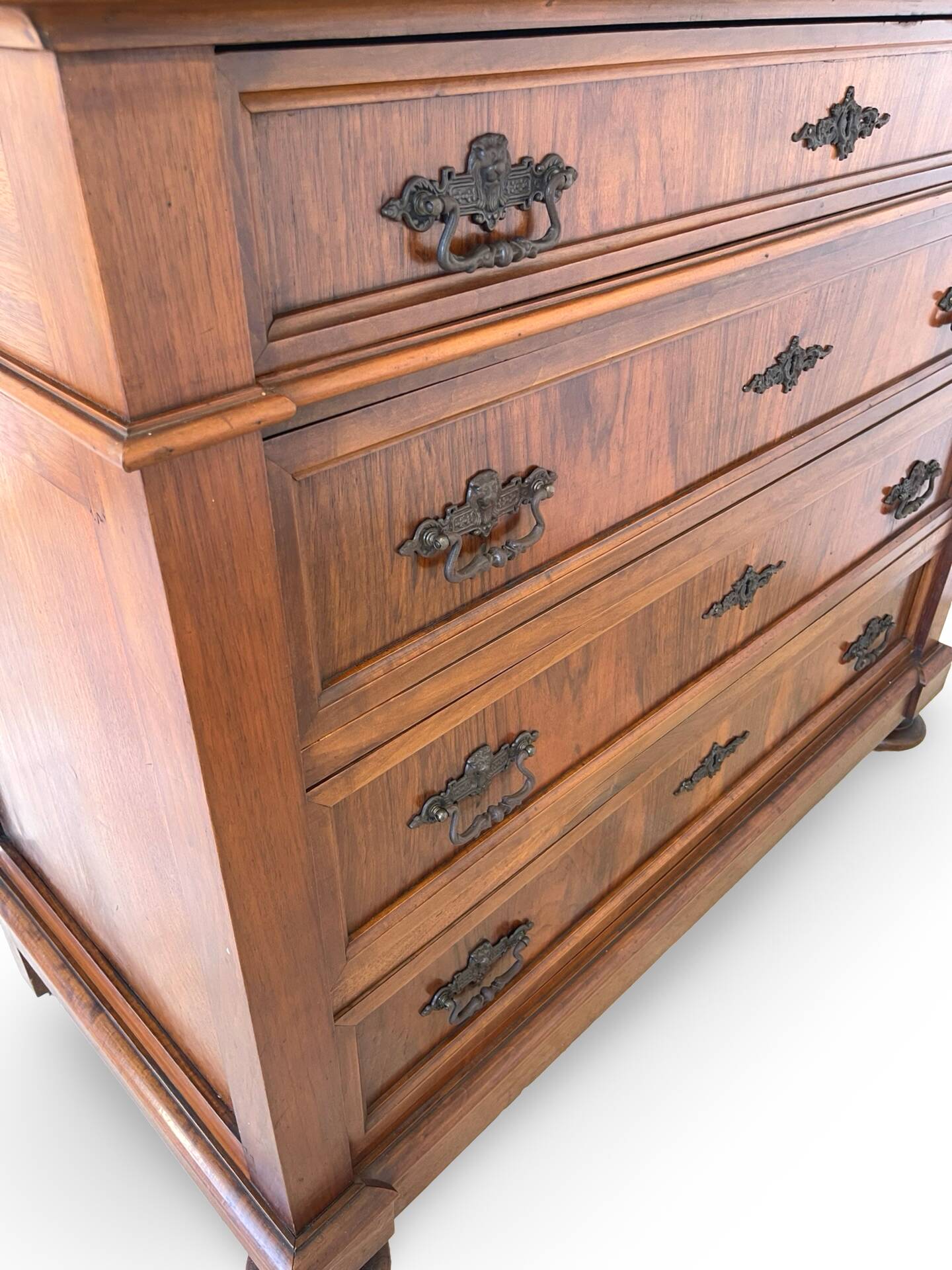 Antique walnut commode with bronze handles in the shape of a lion's mask,