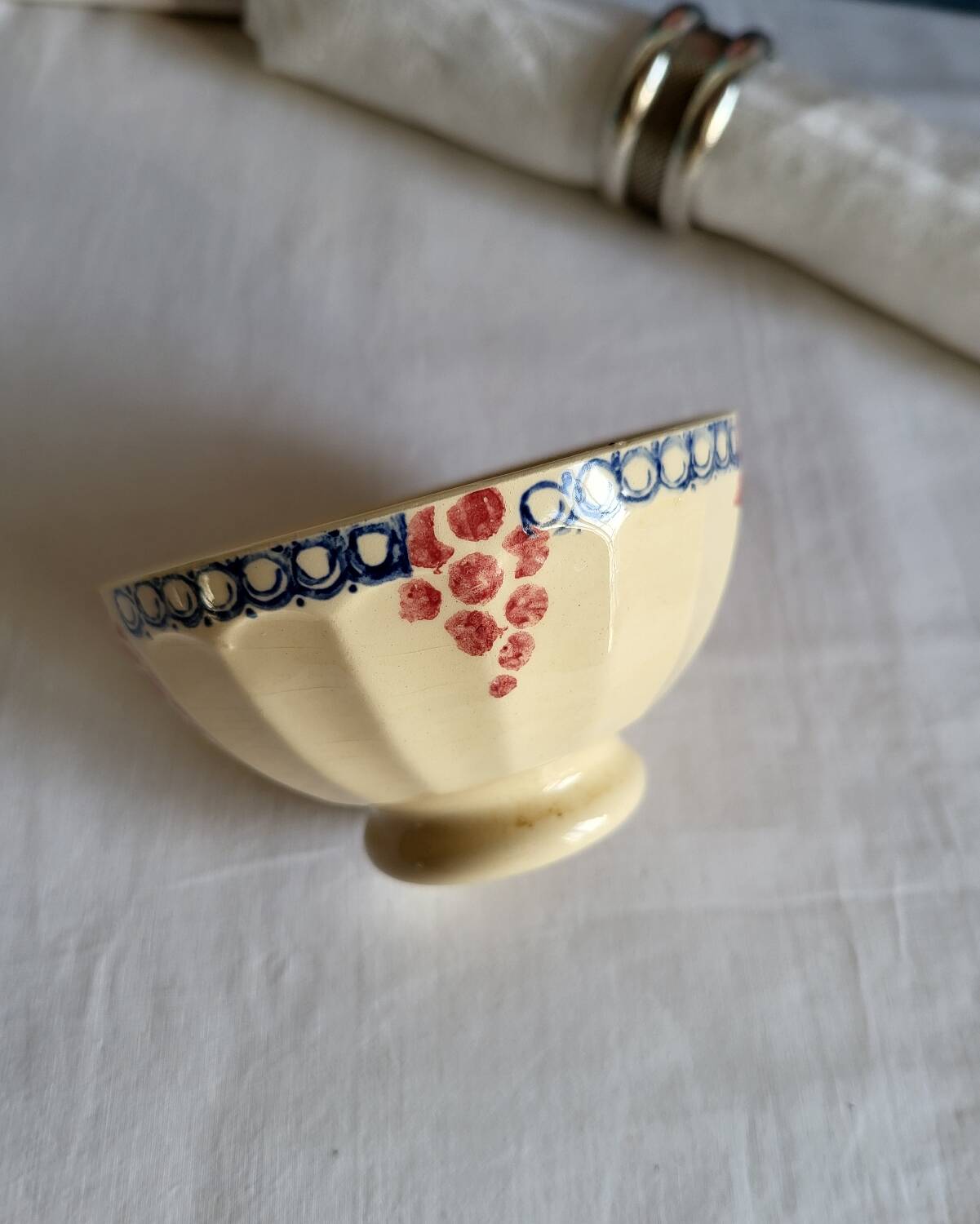 Bol ancien en faïence beige à motif de raisin