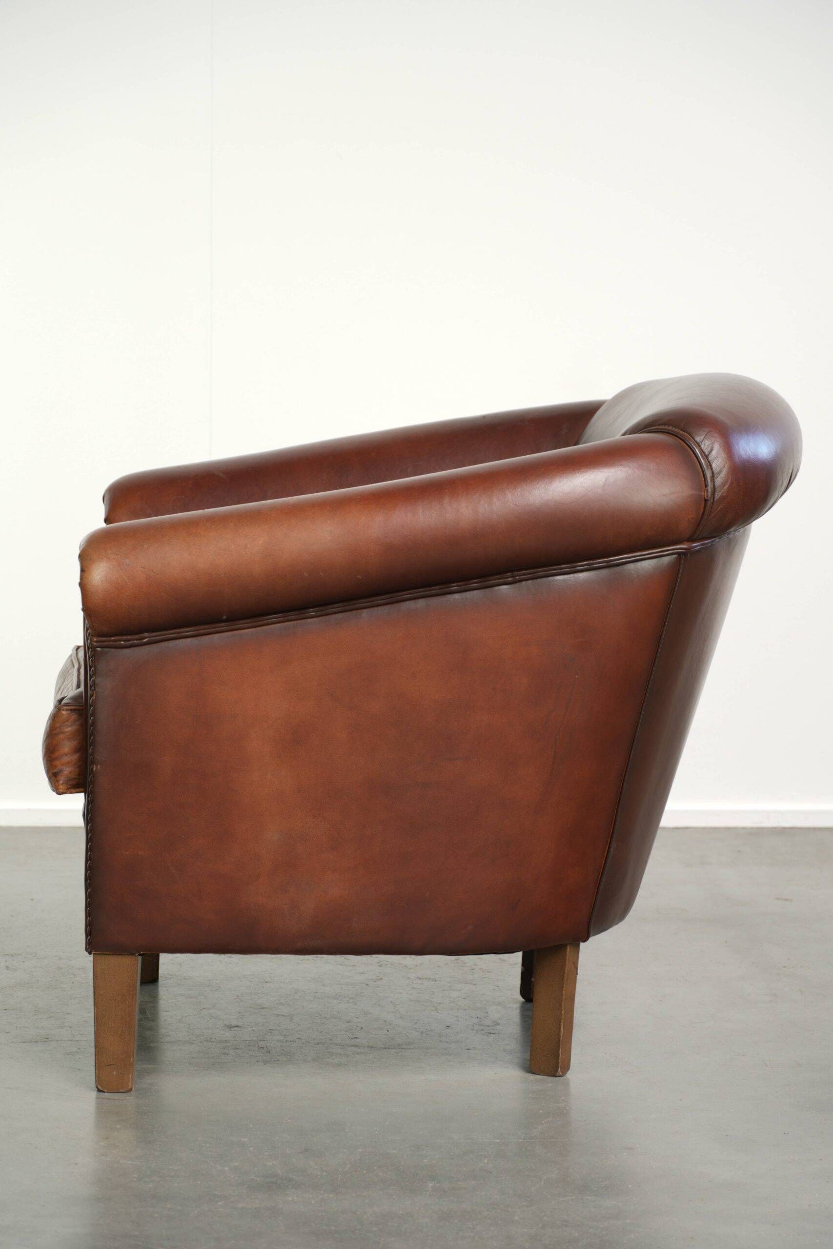 Characterful sheepskin club armchair in a dark cognac colour in English style
