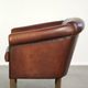 Characterful sheepskin club armchair in a dark cognac colour in English style