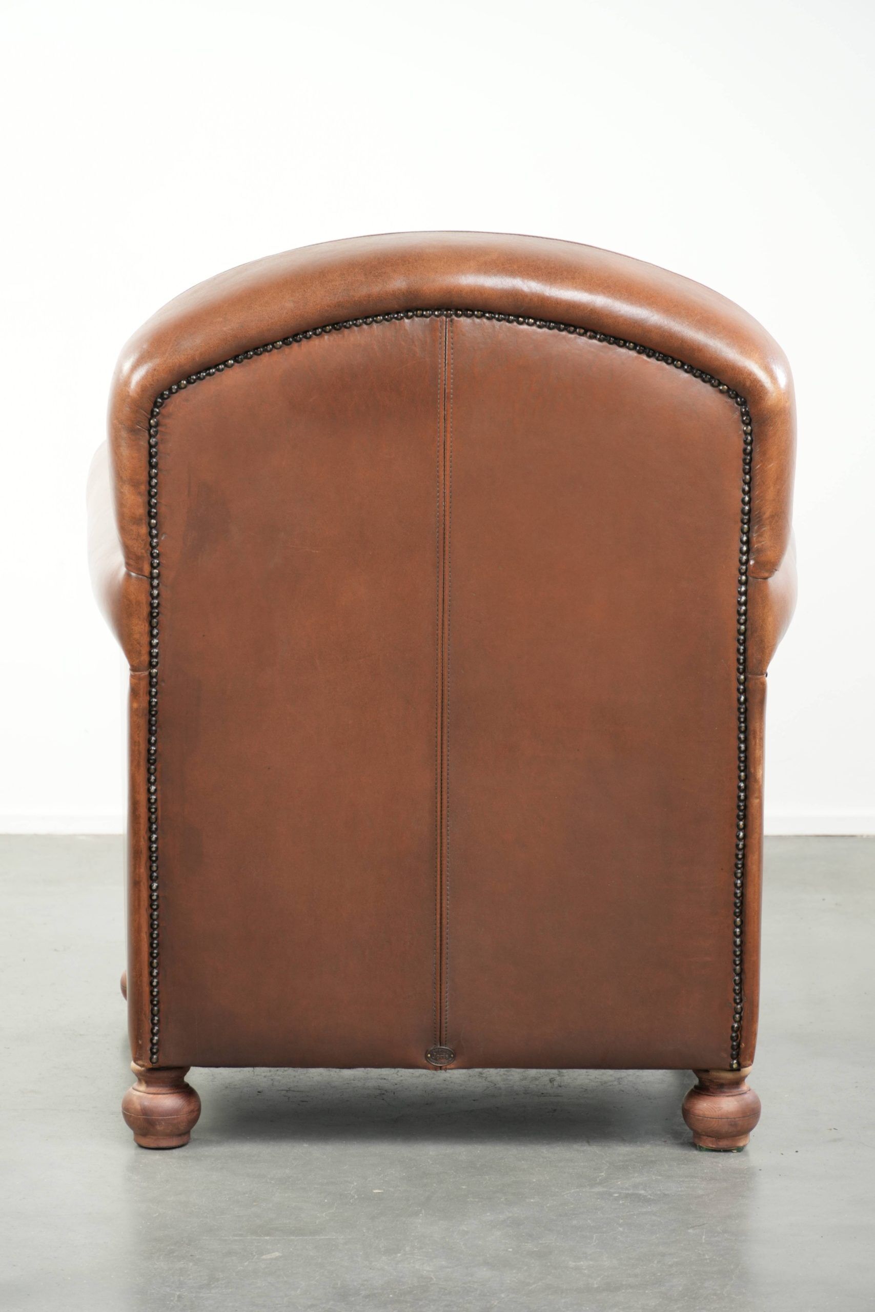Armchair made of sheepskin leather with refined decorative nail finish