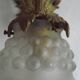 Simple wall sconce in French Art Nouveau bronze with a white glass shade featuring patterns.