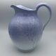 Blue glazed terracotta pitcher with hand-painted decoration, signed