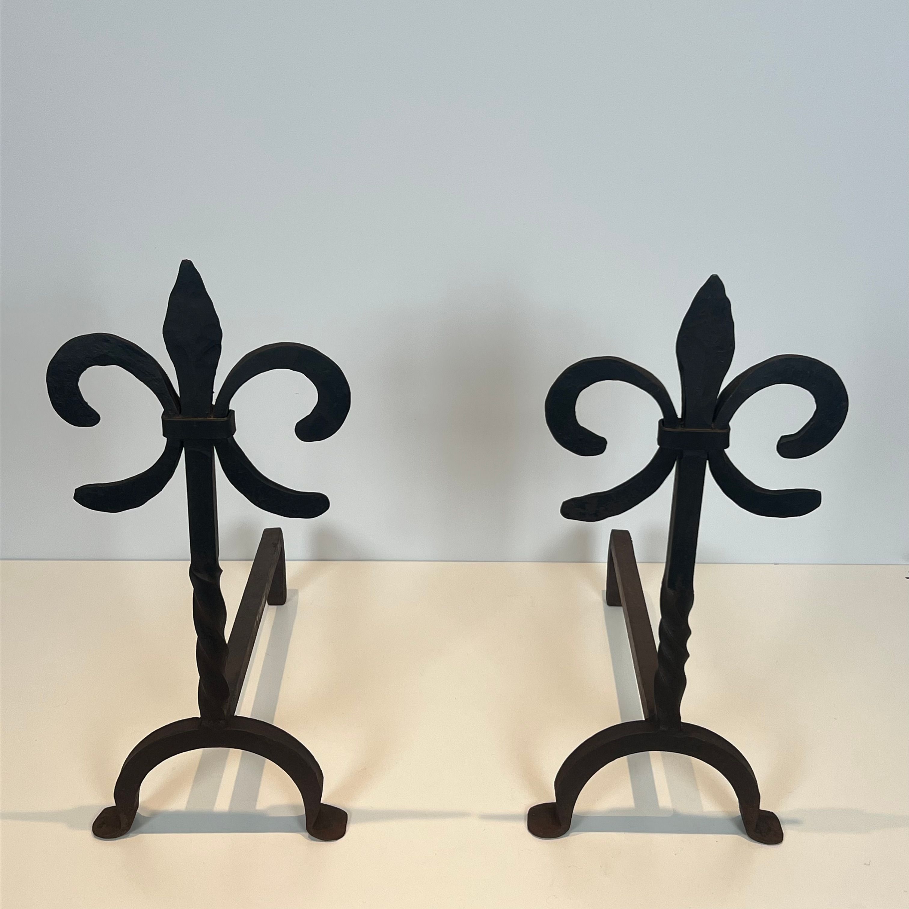 Paire de chenets en fer forgé aux fleurs de lys