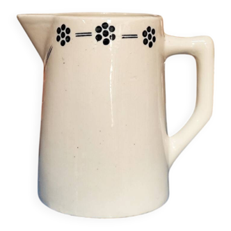 White glazed ceramic pitcher with a geometric flower frieze in blue.