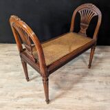 Louis XVI bench in walnut with cane seating.