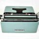 Machine à écrire Olivetti Studio 44 dans son étui avec la clef du coffret