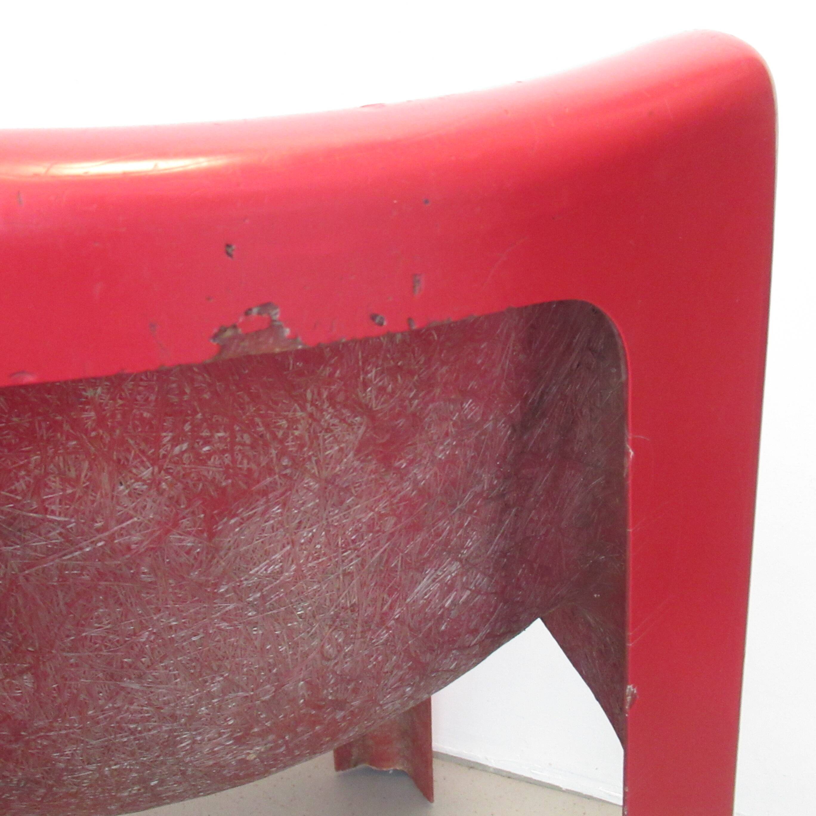 Four red fibreglass chairs from the 1970s.