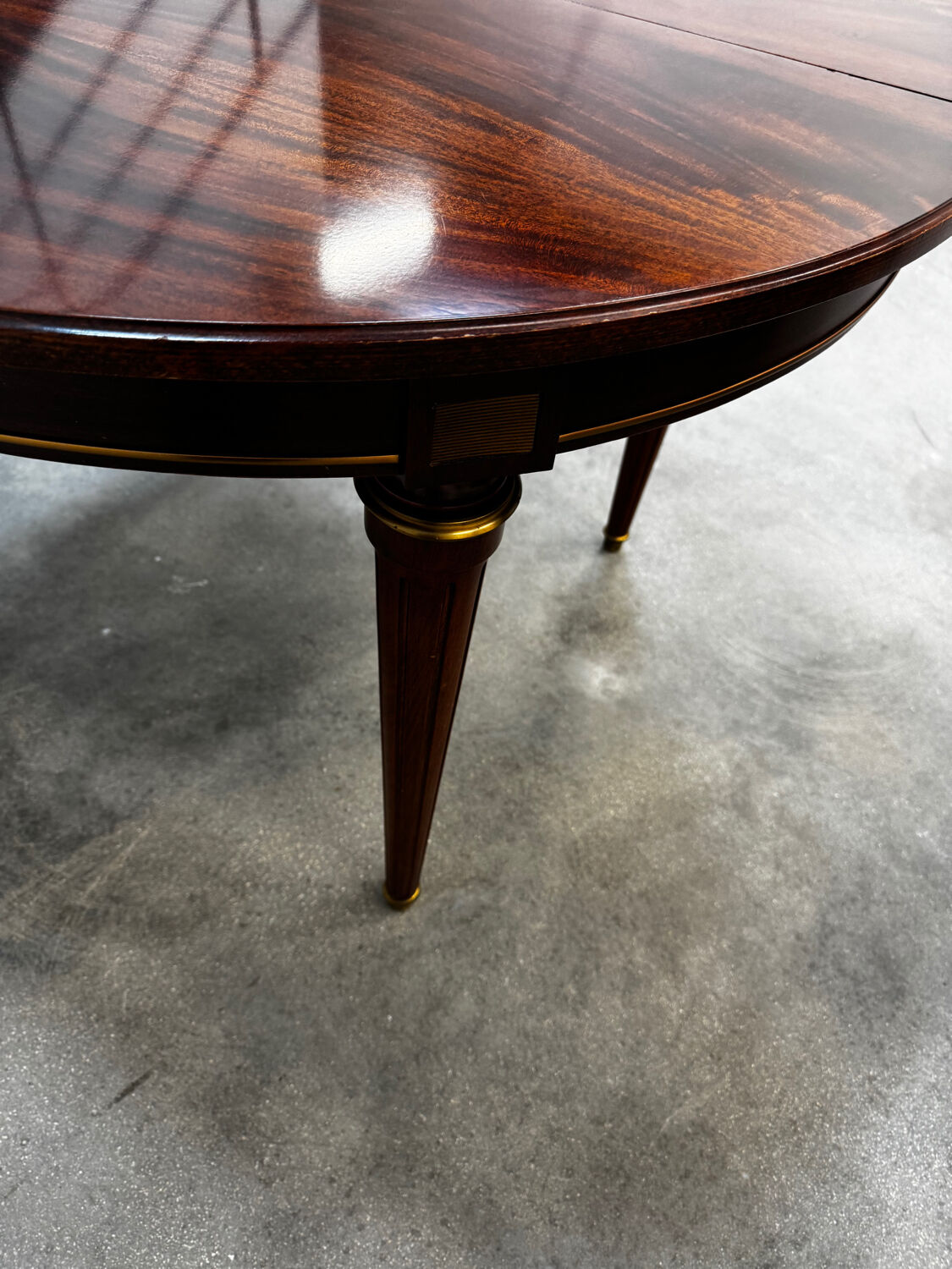 Extendable mahogany round table in Louis XVI style