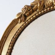 Oval giltwood mirror with rococo-style floral crest, mid-20th century
