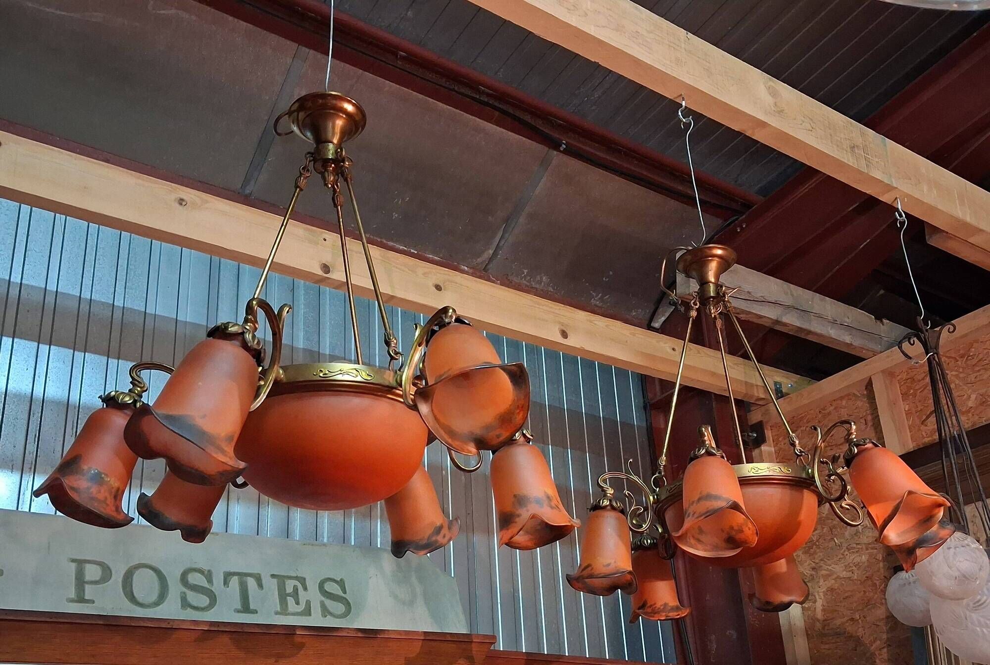 Pair of Art Nouveau style chandeliers in bronze and orange glass paste.