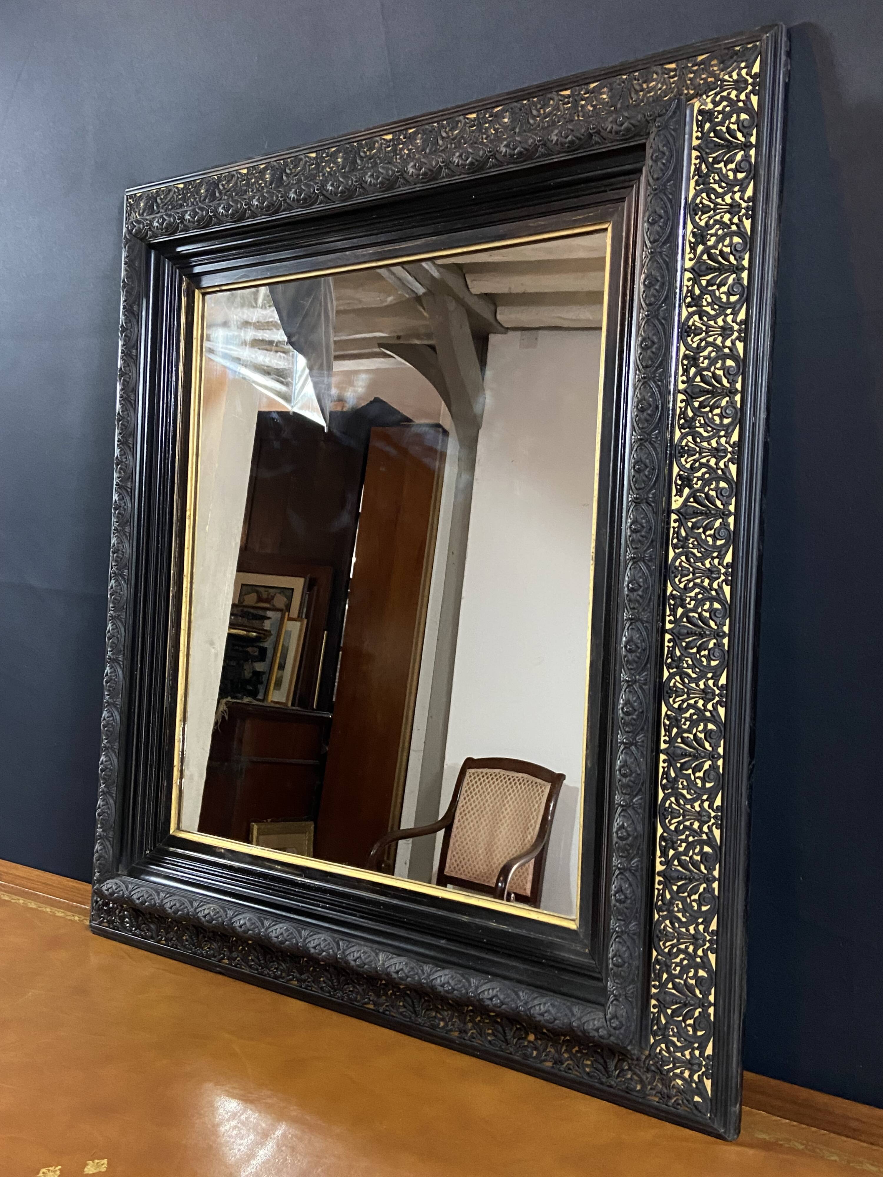 19th-century mirror Napoleon III in blackened wood on a gold background.