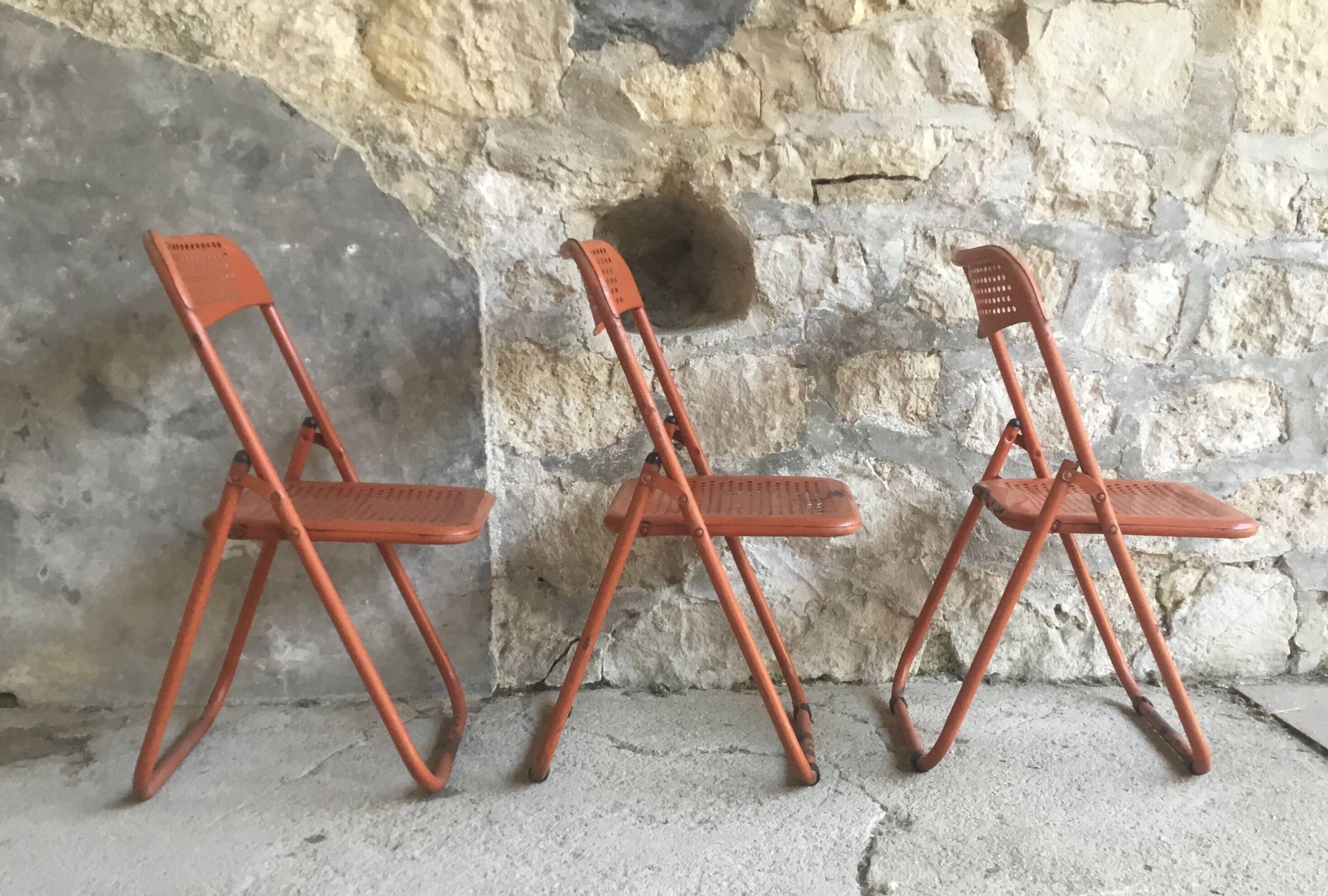 Trio of orange metal folding chairs - vintage