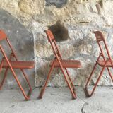Trio of orange metal folding chairs - vintage